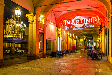 View of Martini Cafe under the arches in shopping arcade at night, Turin, Piedmont, Italy, Europe