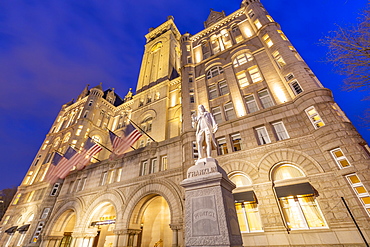 View of Benjamin Franklin statue and US flags in front of former Old Post Office Pavilion, Washington D.C., United States of America, North America