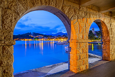 View of town and Crkva Sv. Nikole church through arches at dusk, Cavtat on the Adriatic Sea, Cavtat, Dubrovnik Riviera, Croatia, Europe