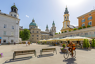 View of cyclist and Salzburg Cathedral in Residenzplatz, Salzburg, Austria, Europe