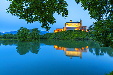View of Trautenfels Castle reflected in nearby lake at dusk, Styria, Austria, Europe