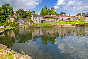 View of cottages reflecting in village pond, Tissington, Peak District National Park, Derbyshire, England, United Kingdom, Europe