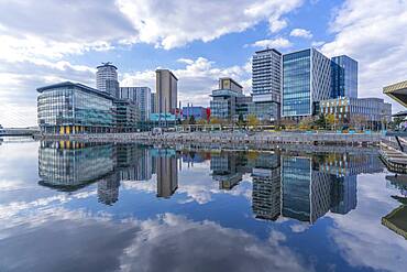 View of MediaCity and clouds reflecting in water in Salford Quays, Manchester, England, United Kingdom, Europe