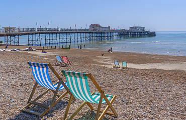 View of Worthing Pier and colourful deckchairs on Worthing Beach, Worthing, West Sussex, England, United Kingdom, Europe