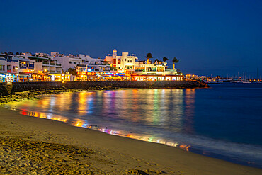 View of restaurants and shops overlooking Playa Blanca Beach at dusk, Playa Blanca, Lanzarote, Canary Islands, Spain, Atlantic, Europe