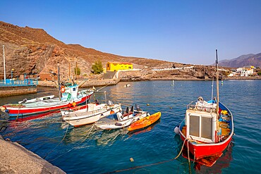 View of colourful boats in harbour and mountains in background, Puerto de La Aldea, Gran Canaria, Canary Islands, Spain, Atlantic, Europe