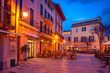 Al fresco eating in local square in the old town of Alcudia at dusk, Alcudia, Majorca, Balearic Islands, Spain, Mediterranean, Europe