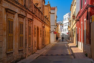 View of couple walking down pastel coloured street in historic centre, Ciutadella, Memorca, Balearic Islands, Spain, Europe