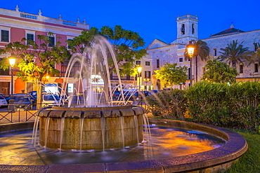 View of fountain and church bell tower in Placa des Born at dusk, Ciutadella, Menorca, Balearic Islands, Spain, Mediterranean, Europe