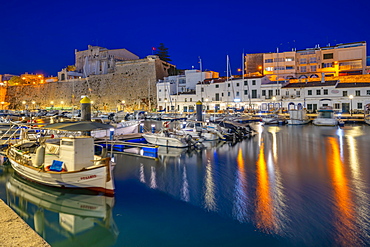 View of boats in marina overlooked by whitewashed buildings at dusk, Ciutadella, Menorca, Balearic Islands, Spain, Mediterranean, Europe