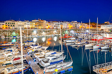 View of boats in marina overlooked by whitewashed buildings at dusk, Ciutadella, Menorca, Balearic Islands, Spain, Mediterranean, Europe