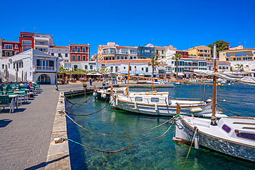 View of colourful cafes, restaurants and boats in harbour against blue sky, Cales Fonts, Menorca, Balearic Islands, Spain, Mediterranean, Europe