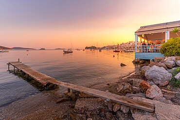 View of boats and restaurants in Skiathos Town at sunset, Skiathos Island, Sporades Islands, Greek Islands, Greece, Europe