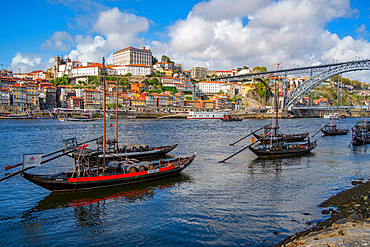 View of the Dom Luis I bridge over Douro River and Rabelo boats aligned with colourful buildings, UNESCO World Heritage Site, Porto, Norte, Portugal, Europe