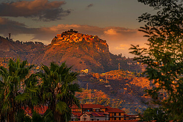 View of hilltop town of Castelmola at sunset from Giardini Naxos, Taormina, Sicily, Italy, Mediterranean, Europe