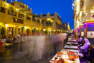 Souq Waqif looking towards the illuminated spiral mosque of the Kassem Darwish Fakhroo Islamic Centre, Doha, Qatar, Middle East