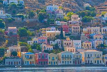 View of clourful houses overlooking harbour of Symi Town, Symi Island, Dodecanese, Greek Islands, Greece, Europe