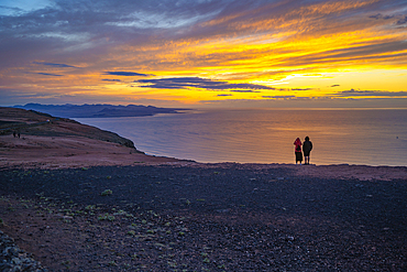 View of couple overlooking volcanic coastline from Mirador del Rio at sunset, Lanzarote, Las Palmas, Canary Islands, Spain, Atlantic, Europe