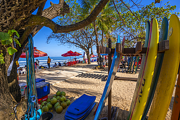 View of surf boards and vendors on sunny morning on Kuta Beach, Kuta, Bali, Indonesia, South East Asia, Asia