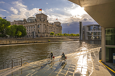 View of cyclists and River Spree and the Reichstag (German Parliament building), Mitte, Berlin, Germany, Europe