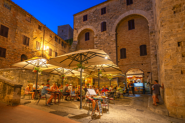 View of restaurant in historic centre at dusk, San Gimignano, UNESCO World Heritage Site, Province of Siena, Tuscany, Italy, Europe