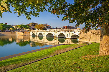 View of Ponte di Tiberio reflecting in Rimini Canal, Rimini, Emilia-Romagna, Italy, Europe