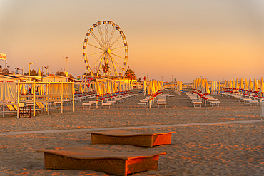 View of ferris wheel and sunshades on the Lido on Rimini Beach at sunrise, Rimini, Emilia-Romagna, Italy, Europe