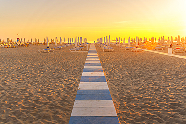 View of sunrise and sunshades on the Lido on Rimini Beach, Rimini, Emilia-Romagna, Italy, Europe