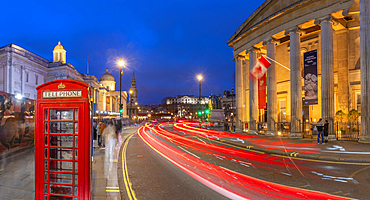 View of red telephone box and Trafalgar Square at dusk, Westminster, London, England, United Kingdom, Europe