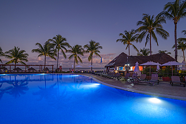 View of hotel pool and sea at dusk near Puerto Morelos, Quintana Roo, Caribbean Coast, Yucatan Peninsula, Riviera Maya, Mexico, North America