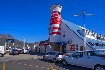 View of colourful bar and lighthouse in Hout Bay Harbour, Hout Bay, Cape Town, Western Cape, South Africa, Africa