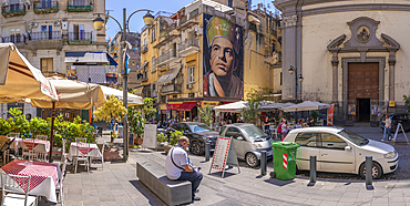 View of cafes and San Gennaro di Jorit Agoch on bustling Via Forcella, Naples, Campania, Italy, Europe