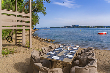 View of alfresco dining table at Dassia Beach and Ionian Sea, Dassia, Corfu, Ionian Sea, Greek Islands, Greece, Europe