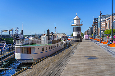 View of Oslo Lighthouse and cafes on the waterfront, Aker Brygge, Oslo, Norway, Scandinavia, Europe