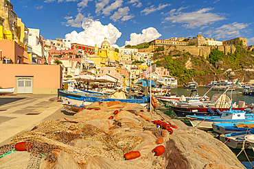 View of fishing nets, boats in Marina di Corricella and Eglise Santa Maria delle Grazie in background, Procida, Phlegraean Islands, Gulf of Naples, Campania, Southern Italy, Italy, Europe