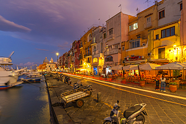 View of shops and Church Madonna delle Grazie in the fishing port Marina Grande with trail lights at dusk, Procida, Phlegraean Islands, Gulf of Naples, Campania, Southern Italy, Italy, Europe