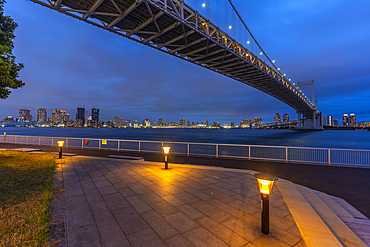 View of the Rainbow Bridge and Koto City in background at dusk, Minato City, Tokyo, Honshu, Japan