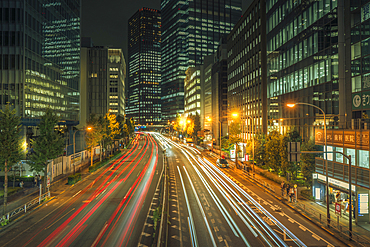 View of city street and trail lights at night, Minato City, Tokyo, Honshu, Japan