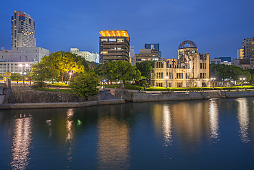 View of the skeletal ruins of the A-Bomb Dome from Hiroshima Peace Gardens at dusk, UNESCO, Hiroshima, Honshu, Japan