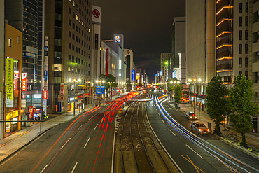 View of street scene, trail lights and shopping mall in Hiroshima at night, Hiroshima, Honshu, Japan