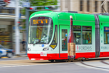 Close view of city tram on major street during daytime, Hondori, Naka Ward, Hiroshima, Japan, Asia