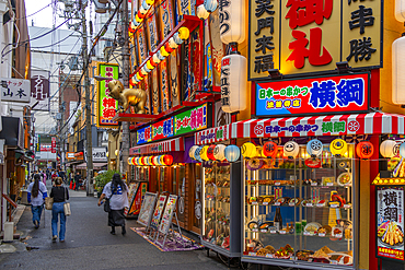 View of colourful facades of shops and restaurants in Dotonbori, vibrant entertainment district near the river, Osaka, Honshu, Japan