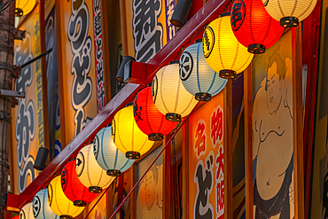 View of colourful facades of shops and restaurants in Dotonbori, vibrant entertainment district near the river, Osaka, Honshu, Japan