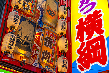 View of colourful facades of shops and restaurants in Dotonbori, vibrant entertainment district near the river, Osaka, Honshu, Japan