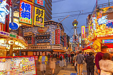 View of Tsutenkaku Tower and restaurants neon lights at dusk in the Shinsekai area, Osaka, Honshu, Japan