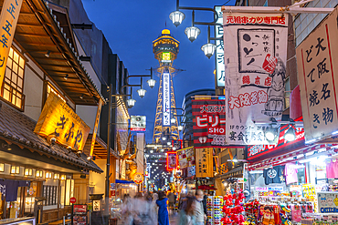 View of Tsutenkaku Tower and restaurants neon lights at dusk in the Shinsekai area, Osaka, Honshu, Japan