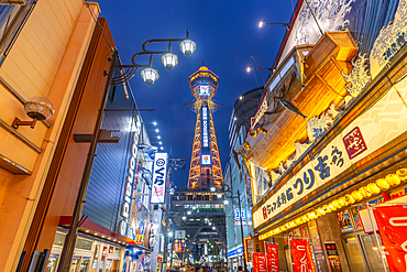 View of Tsutenkaku Tower and restaurants neon lights at dusk in the Shinsekai area, Osaka, Honshu, Japan