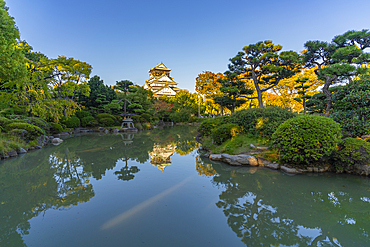 View of Osaka Castle reflecting in Japanese garden pond at sunset, Osakajo, Chuo Ward, Osaka, Honshu, Japan, Asia