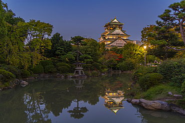 View of Osaka Castle reflecting in Japanese garden pond at dusk, Osakajo, Chuo Ward, Osaka, Honshu, Japan, Asia