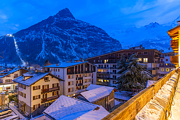 View of snow covered rooftops with mountainous background at dusk, Courmayeur, Aosta Valley, Italy, Europe